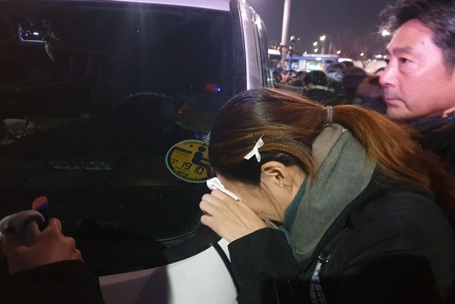 ▲ 문 기수의 시신을 실은 운구차가 서울 오던 날 고개를 숙이고 울고 있는 오은주 씨. 공공운수노조 제공.