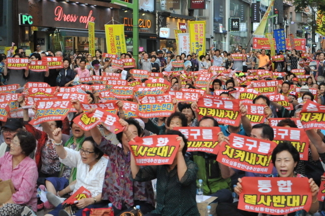 ▲ 지난 7월 15일 오후 6시 중구 남포동 옛 미화당백화점 앞에서 열린 '중구민 총 궐기대회'에 참여한 시민들이 원도심 통합 반대 피켓을 들고 있다. ⓒ프레시안(박호경)