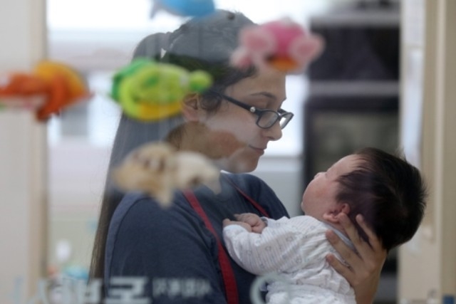 ▲ 자원봉사자가 입양될 아기를 돌보고 있다. ⓒ연합뉴스
