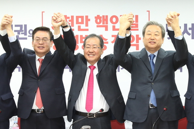▲홍준표 자유한국당 대표(가운데)가 9일 오전 서울 여의도 당사에서 열린 '재입당 국회의원 간담회'에서 바른정당을 탈당해 재입당한 김무성 의원(오른쪽)과 손을 잡고 있다. 왼쪽은 정우택 원내대표. ⓒ연합뉴스