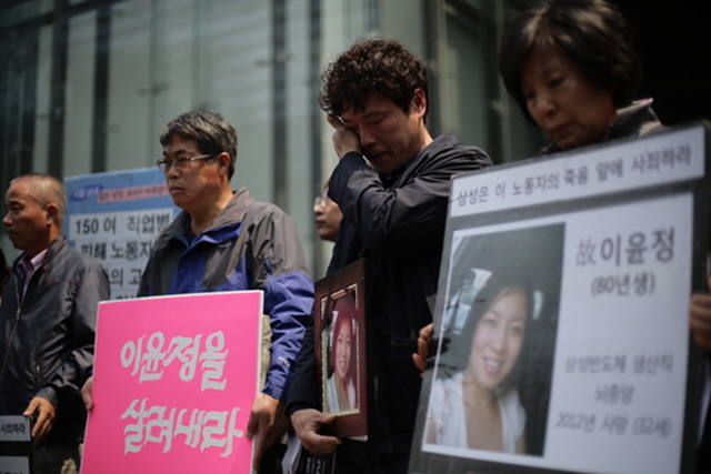 ▲ 고(故) 이윤정 씨 1주기 추모행사에서 이 씨의 남편 정희수 씨가 고인의 영정 사진을 들고 눈물을 흘리고 있다.ⓒ프레시안(최형락)