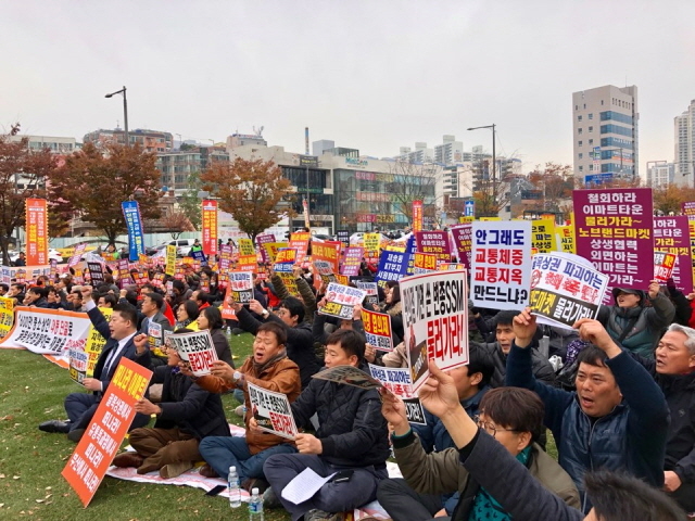 ▲ 22일 부산 부산진구 송상현광장에서 열린 '만 명 상인 궐기대회'에 참여한 중소상인들이 피켓을 들고 구호를 외치고 있다. ⓒ프레시안(홍민지)