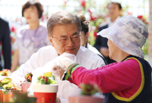 ▲ 문재인 대통령이 2017년 6월 2일 서울시 국민건강보험 서울요양원에서 치매 어르신을 만나고 있다. ⓒ청와대