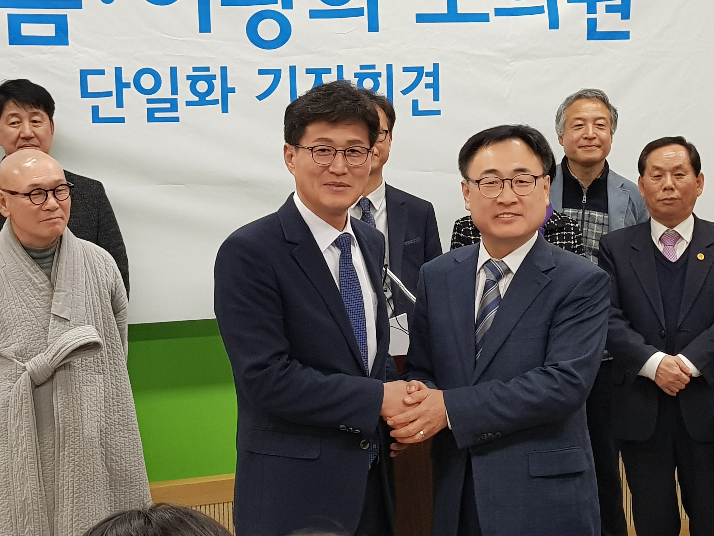 청주시장 후보단일화를 통해 시장후보로 결정된 이광희 충북도의원(오른쪽)과 고배를 마신 연철흠 도의원이 두손을 맞잡고 포즈를 튀하고 있다.