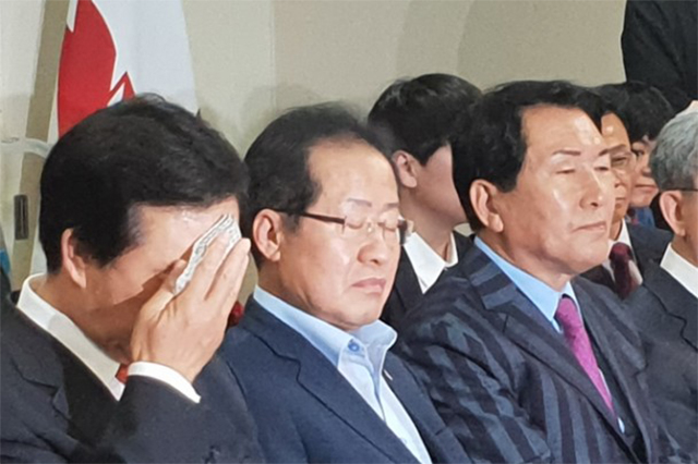 ▲6.13지방선거 출구조사 결과를 본 자유한국당 홍준표 대표가 눈을 감고 있다. 김성태 원내대표는 손수건으로 땀을 닦고 있다. ⓒ프레시안(이정규)