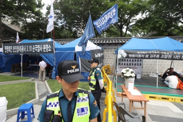 ▲ 경찰이 친박단체의 천안함 분향소(왼쪽)와 금속노조의 쌍차 분향소(오른쪽) 간 충돌을 우려해 폴리스라인을 설치한 채 근무를 서고 있다. ⓒ연합뉴스