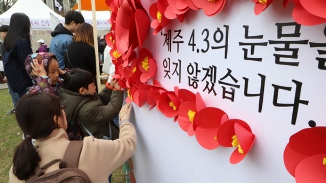 ▲ 서울 광화문 광장에서 열린 문화제에 참가한 국민들이 동백꽃을 달고 있다. ⓒ제주의소리