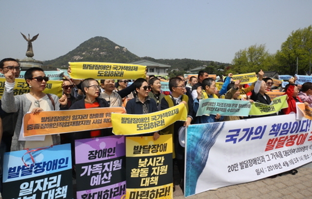 ▲ 전국장애인부모연대 회원들이 장애인의 날을 하루 앞둔 2018년 4월 19일 서울 종로구 청와대 분수대 광장에서 발달장애 국가책임제 도입을 촉구하며 구호를 외치고 있다. 이날 기자회견에서 참가자들은 발달장애인 일자리 대책과 낮시간 활동지원 대책 마련, 발달장애인 가족지원 예산 확대 등을 요구했다. ⓒ연합뉴스