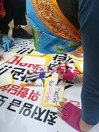 ▲ 레이테크코리아 임태수 사장이 사는 아파트 단지 앞에서 해고된 노동자가 자신의 요구를 적고 있다. ⓒ희정