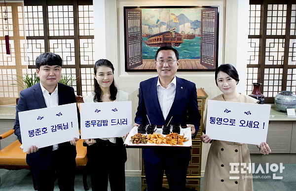 ▲강석주 통영시장이 봉준호 감독을 초대하고 있다. 강 시장의 손에 충무김밥이 들려있다. ⓒ통영시