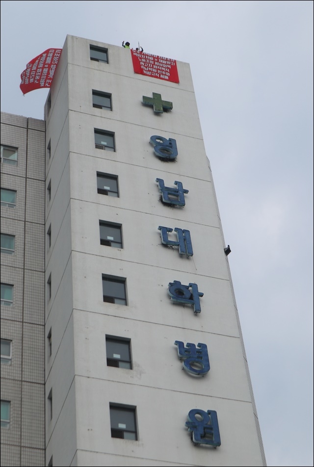 ▲ 영남대병원 응급센터 70m 옥상서 고공농성 중인 해고자들(2019.7.1.). ⓒ평화뉴스(김영화)