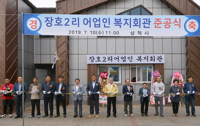 ▲10일 삼척시 장호2리 현지에서 김양호 삼척시장과 어업인 등이 참가한 가운데 장호2리 어업인 복지회관 준공식 테이프 커팅식을 진행하고 있다. ⓒ삼척시