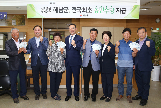 ▲ 전남 해남군은 전국 최초로 지자체 단위에서 농민수당을 지급키로 했다. 지난 달 26일 해남 옥천농협에서 명현관(왼쪽에서 네번째) 해남군수와 관계자들이 농업인 대표 4명에게 농민수당을 지급하는 전달식을 가졌다. ⓒ해남군 제공