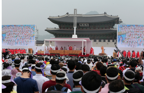 ▲ 프란치스코 교황이 2014년 8월 16일 광화문광장에서 열린 시복미사에서 윤지충 바오로와 동료 순교자 123위를 복자로 선포하는 순간 이들 124위가 함께 그려진 대형 걸개그림이 공개되자 참석한 신자들이 박수로 환호하고 있다. ⓒ연합뉴스