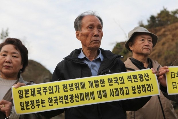 ▲ 2010년 한일합방 100년을 맞아 한국의 광산석면피해자와 일본센난지역의 재일한국인 석면피해자들이 국내 최대 석면피해지역인 충남 홍성 광천광산에 모여 일본정부의 책임을 묻는 손팻말을 들고 있다. ⓒ최예용